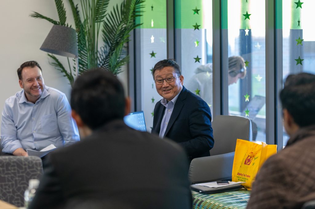 Man sitting and smiling in a group of people