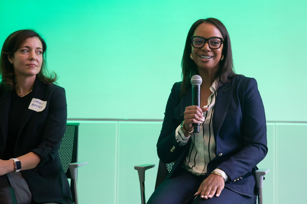 Two women sitting and speaking into microphones