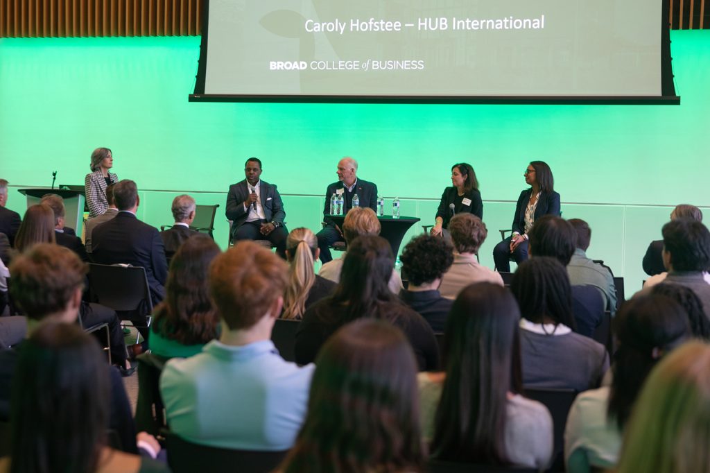 Group of people sitting and watching 5 panelists