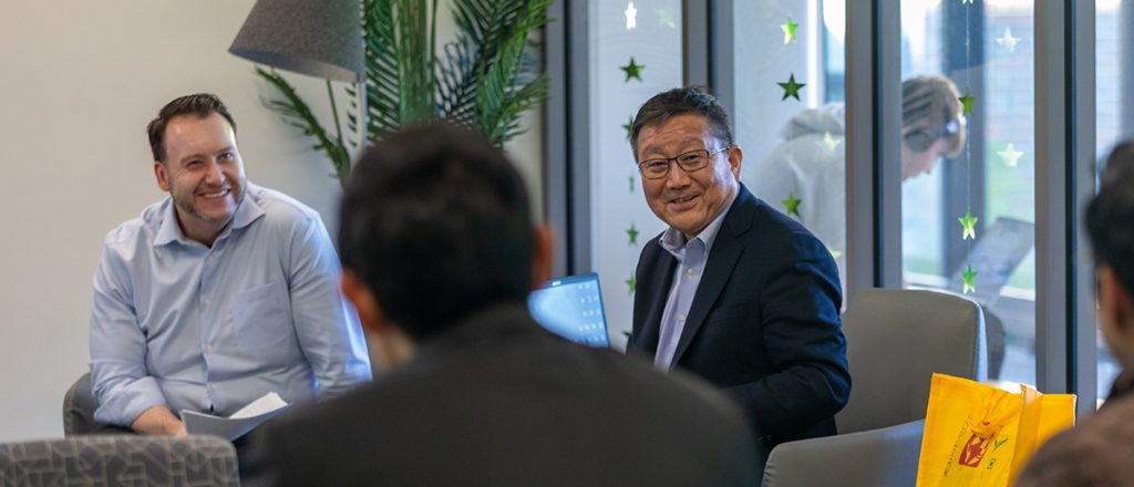 Mr. Keiichi Higuchi sitting down and talking with Broad College of Business Faculty and Staff.