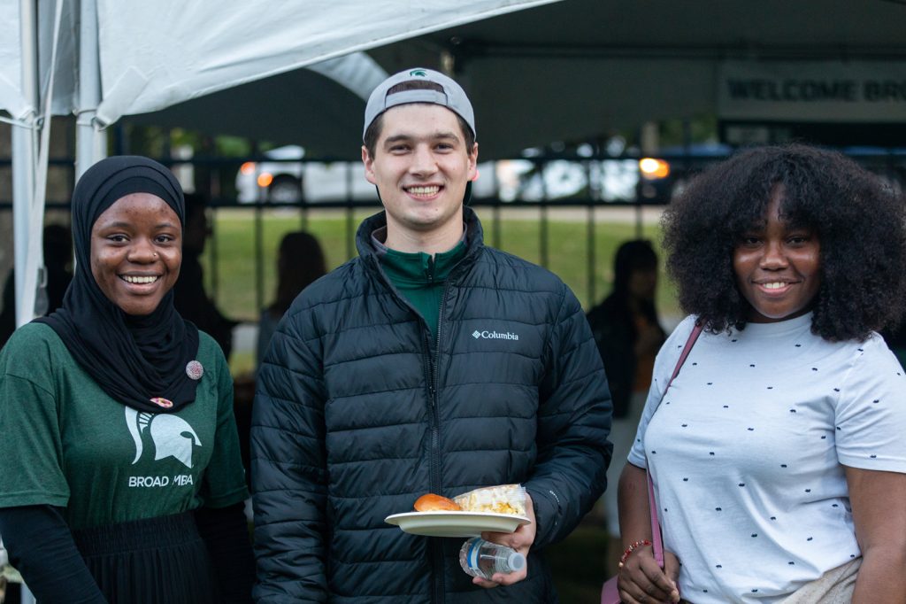 Students taking a group photo at the MBA Homecoming Tailgate