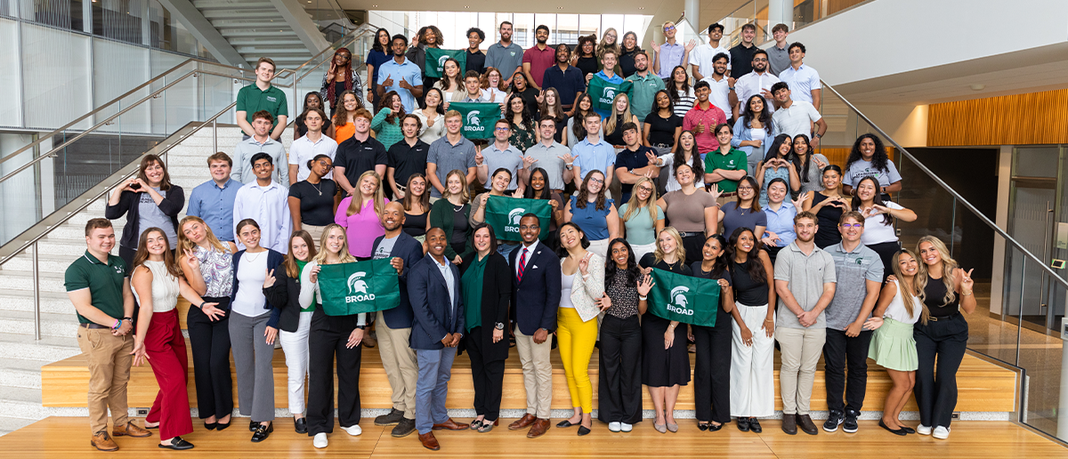 A group of broad faculty, staff and students together on the steps of Minskoff Pavilion.
