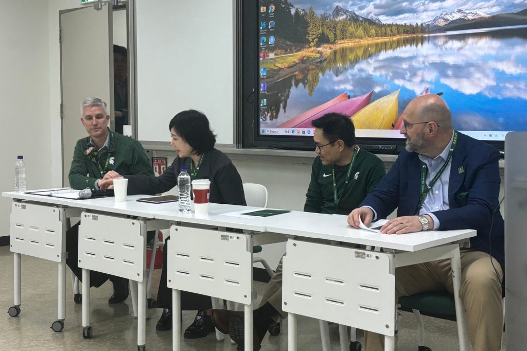 Panelists seated at desks