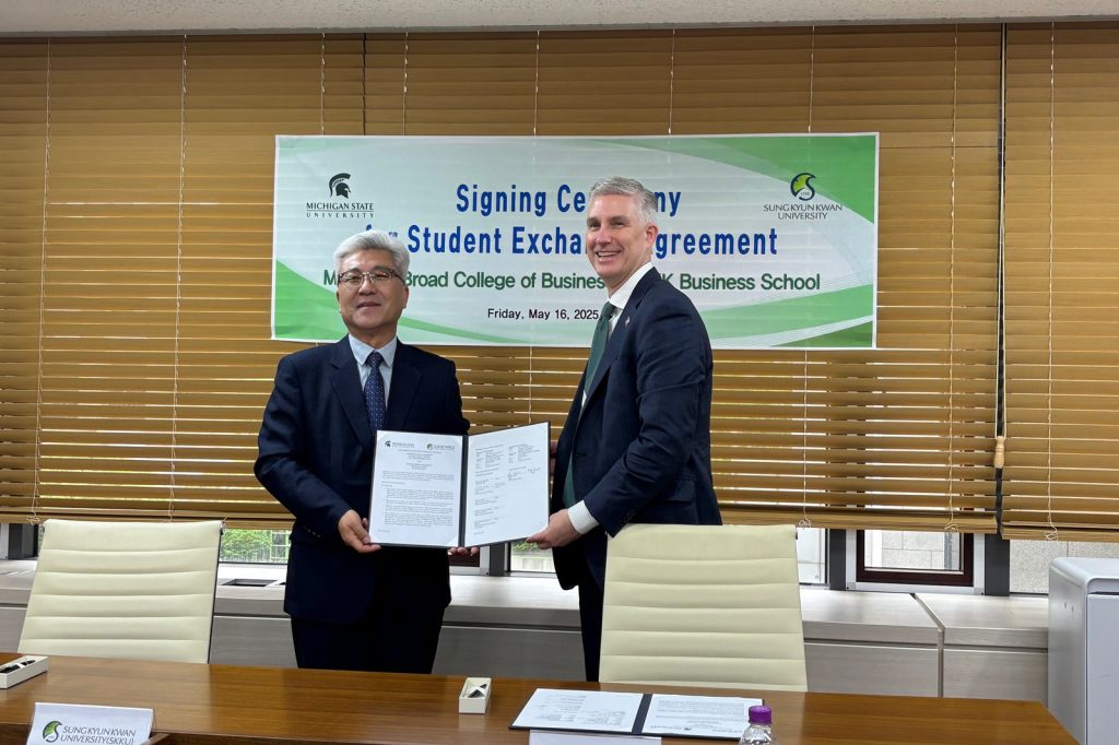 Two deans holding signed agreement