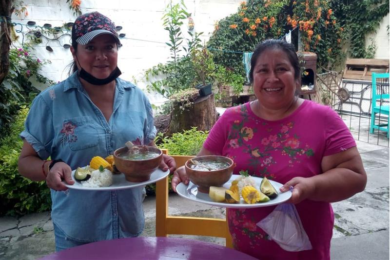 Two people holding plates of food