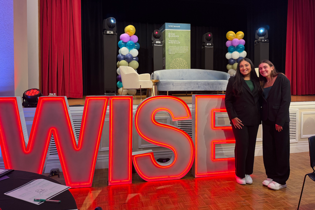 Students with WISE neon sign