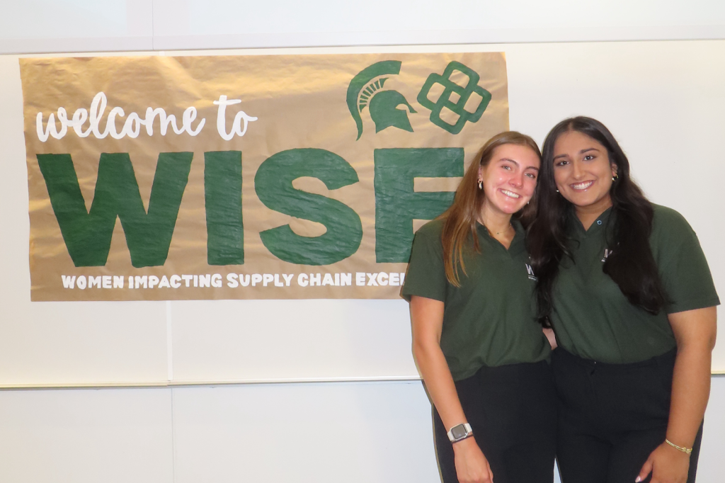 Rolison and Rana in front of WISE sign