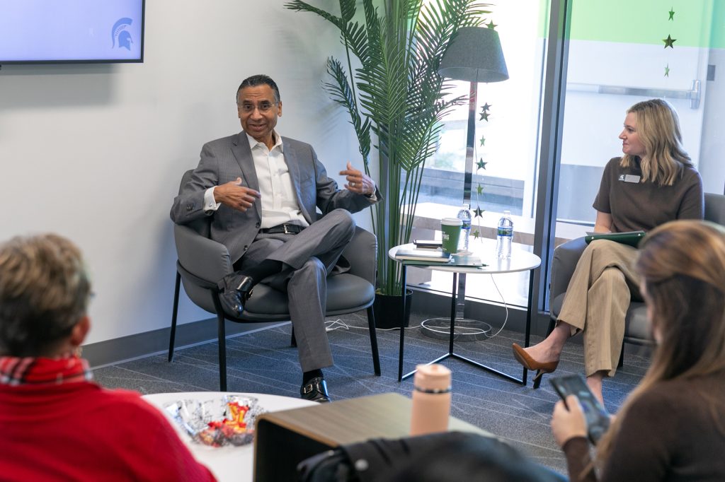 Lalwani sitting with group of staff
