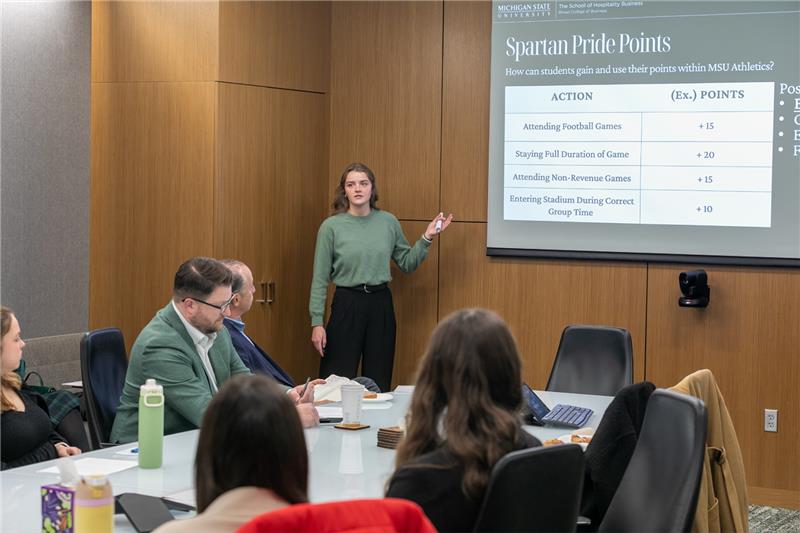 Person presenting slideshow to seated board room