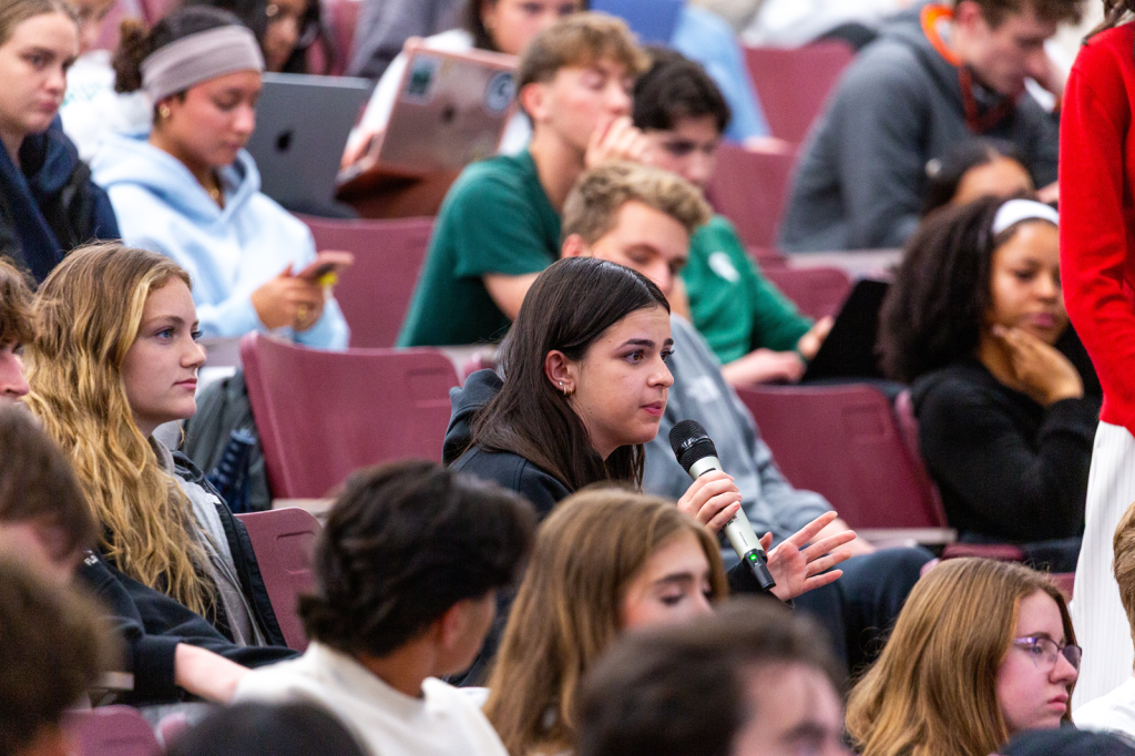 Seated student speaking into microphone