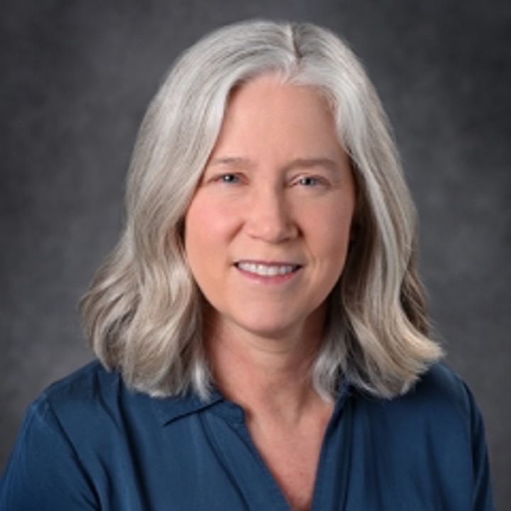 A professional headshot of Chris Hogan