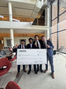 4 students hold a giant check after winning a case competition