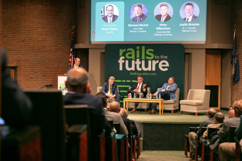 Three panelists speaking with audience listening