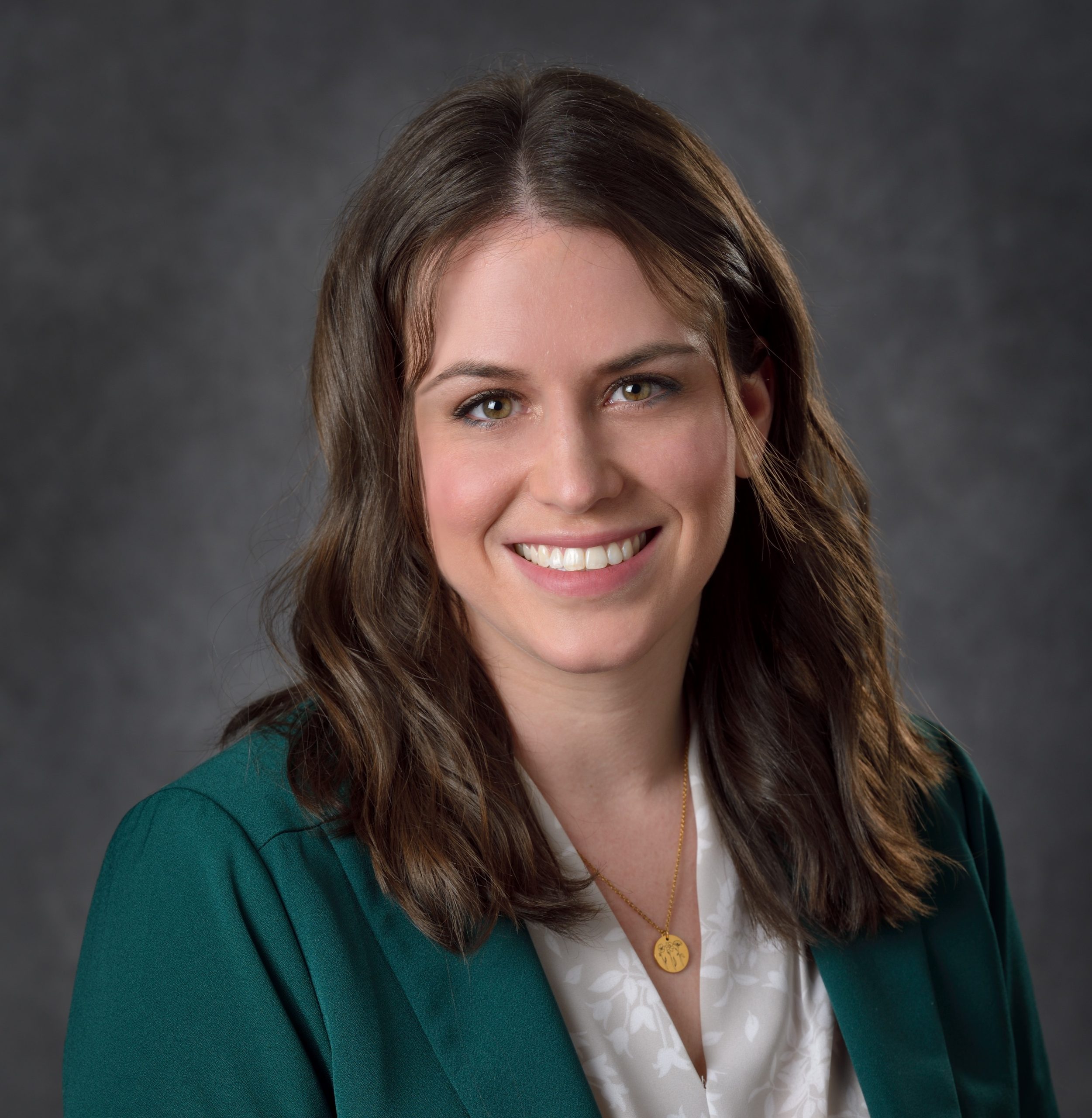 Kristina Reitler headshot - woman smiling in green blazer