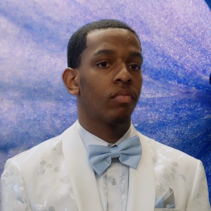 young man in a white suit with a light blue bow tie