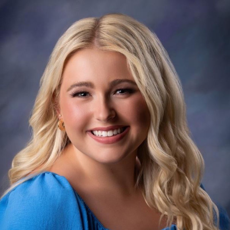 Profile picture of a woman with a medium blue shirt smiling