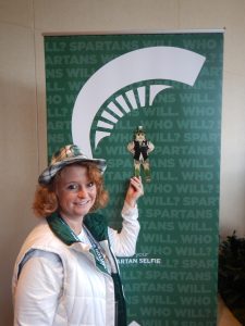 Allegra Johnson and Thin Business Sparty in front of a MSU photo-taking backdrop.