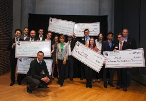 Group shot of students holding checks