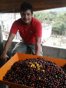 Victor stands next to a coffee roaster