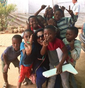 An Executive MBA student takes a picture with children in Kliptown