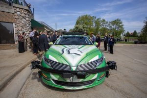 Attendees at the Workshop on Autonomous Vehicles in Society inspect a driverless car during the mid-May conference at the James B. Henry Center for Executive Development in Lansing. Photo by Jeff Seguin