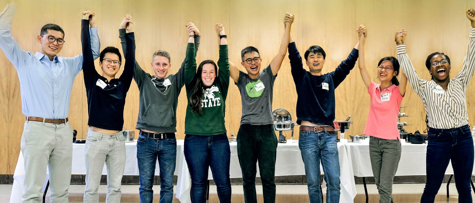 Michigan State M.S. in Accounting students raising hands in air in excitement.