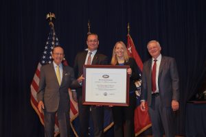 Tomas Hult and Jade Sims pose with two U.S. Commerce officials while accepting the President's "E" Award