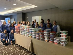 Big Ten Women's Conference attendees pose with more than 100 boxes of hygiene and cosmetic items that were assembled for Detroit's women in need.