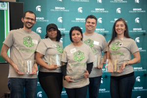 Executive MBA 2020 Pitch Competition winning team wearing Perfect Hedge t-shirts, holding first place awards.