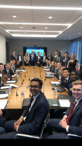 The Financial Markets Institute scholars with Department of Finance Chairperson Andrei Simonov seated and standing around a conference room table.