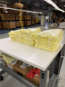 Medical gowns folded and stacked at a Carhartt manufacturing facility.