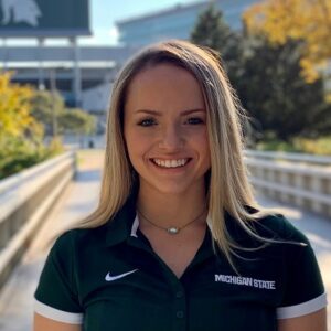 Madison Genord (B.A. Marketing '21) outside on MSU's campus in front of the Spartan Stadium.