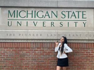 Simone Nagi posing in front of a Michigan State University sign